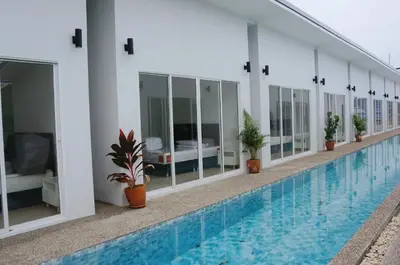 a hotel swimming pool with potted plants next to it at A&J Holiday Villa in Ban Na Bon