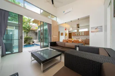 a living room with a couch and a table at Mahogany Superb Pool Villa in Pasak in Phuket