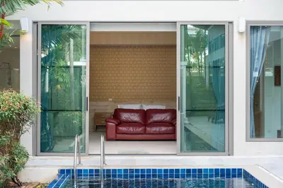 a red couch sitting on the side of a house at Mahogany Superb Pool Villa in Pasak in Phuket