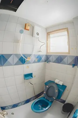 a bathroom with a blue toilet and a window at xx Mitr Inn - Phuket Old Town มิตรอินน์ ภูเก็ต เมืองเก่า 3 in Phuket Town