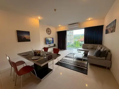 a living room with a couch and a table and chairs at Chic B309 in Karon Beach