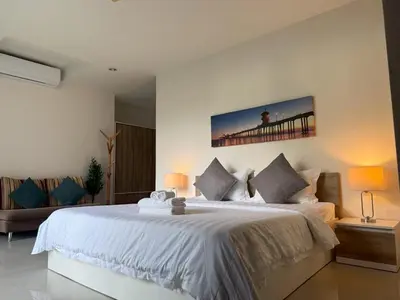 a bedroom with a large white bed and a pier at Chic B309 in Karon Beach