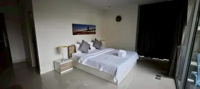 a white bedroom with a bed and a window at Chic B309 in Karon Beach