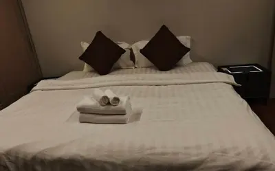 a white bed with two towels and two shoes on it at Palm Spring 301 in Patong Beach