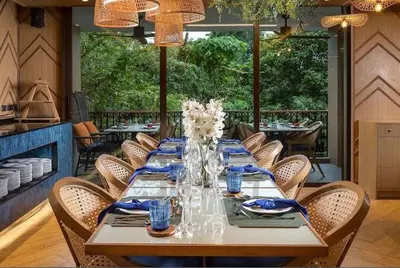 a dining room with a long table and chairs at Cozy 2BR Apartment in The Proud Karon Beach in Karon Beach