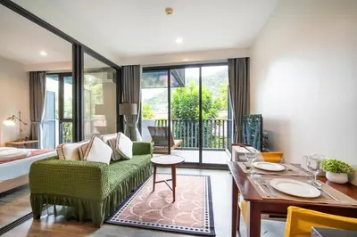 a living room with a green couch and a table at \u65b0\u623f\u7279\u60e0 \u82ad\u4e1cThe Deck43\u7cbe\u88c5\u4e00\u5367\u5ba4\u516c\u5bd3\u5e26\u6d74\u7f38 \u8fd1\u82ad\u4e1c\u6d77\u6ee9Bangla\u6c5f\u897f\u51b7 in Patong Beach