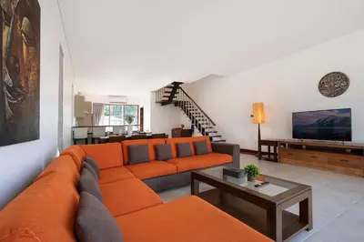 a living room with an orange couch and a television at 3 BR Villa with swimming pool near golf and airport - Argent 10 in Thalang