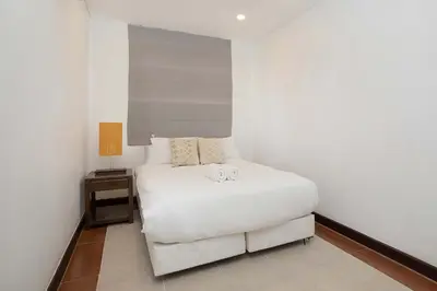 a small bedroom with a white bed and a table at 3 BR Villa with swimming pool near golf and airport - Argent 10 in Thalang