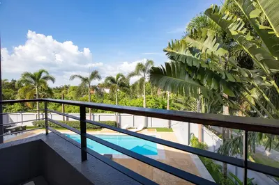 a balcony with a swimming pool and palm trees at 3 BR Villa with swimming pool near golf and airport - Argent 10 in Thalang