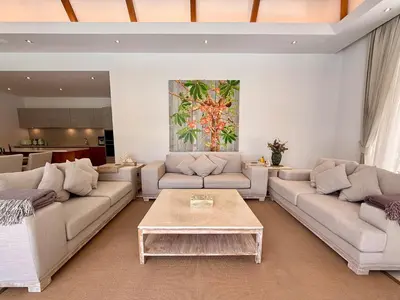 a living room with couches and a coffee table at Peaceful villa in the heart of the Anchan Tropicana project in Ban Phru Champa