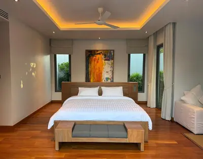 a bedroom with a bed and a ceiling fan at Peaceful villa in the heart of the Anchan Tropicana project in Ban Phru Champa