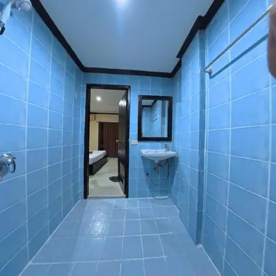 a blue bathroom with a sink and a mirror at Stay 94 Patong in Patong Beach