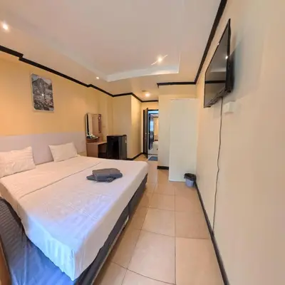 a bedroom with a bed and a flat screen tv at Stay 94 Patong in Patong Beach