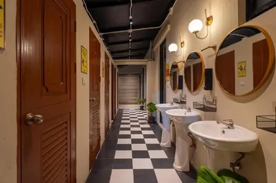 a bathroom with three sinks and a checkered floor at Whoopers Hostel Ao Nang - By The Beach in Ban Khlong Haeng