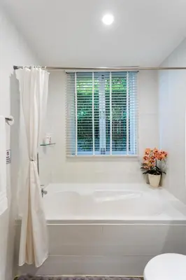 a white bathroom with a tub and a window at Villa Vie Phuket Rawai 3 Bedrooms in Ban Saiyuan (1)