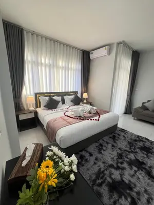 a bedroom with a bed and a table with flowers on it at Ali House Patong in Patong Beach