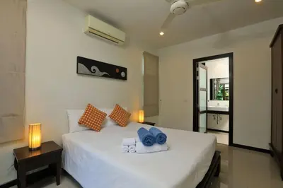 a bedroom with a white bed with blue towels on it at VILLA HENI Private pool 3BR villaNaiharn beach in Nai Harn Beach