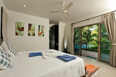 a bedroom with a white bed and a large window at VILLA HENI Private pool 3BR villaNaiharn beach in Nai Harn Beach