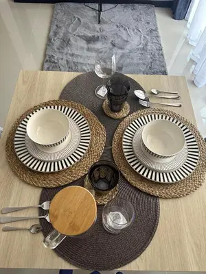 a wooden table with plates and utensils on it at Комфортные апартаменты Пхукет NBC in Rawai Beach
