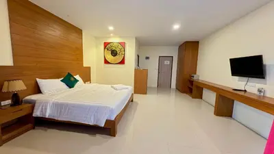 a bedroom with a bed and a flat screen tv at Baan Phu Chalong Place in Ban Suan