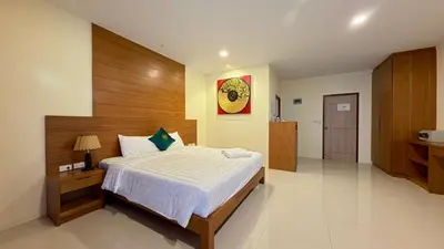 a bedroom with a large bed with a wooden headboard at Baan Phu Chalong Place in Ban Suan