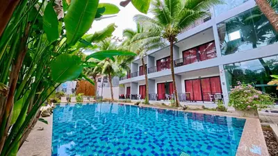 a swimming pool in front of a building at Baan Phu Chalong Place in Ban Suan