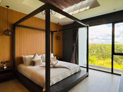 a bedroom with a canopy bed and a large window at Tierra Utopia