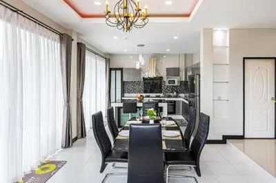 a dining room with a long table and black chairs at Kathu V pool villa 170 in Kathu