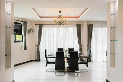 a dining room with a table and black chairs at Kathu V pool villa 170 in Kathu