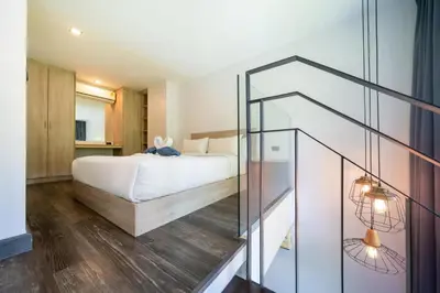 a bedroom with a bed and a glass staircase at Stylish Loft at Utopia Nai Harn great amenities in Rawai Beach