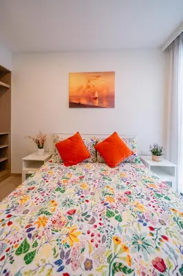 a bed with two orange pillows in a bedroom at Sky park 2 bedroom 60m2 in Laguna Phuket