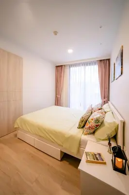 a bedroom with a bed with a desk and a window at Sky park 2 bedroom 60m2 in Laguna Phuket
