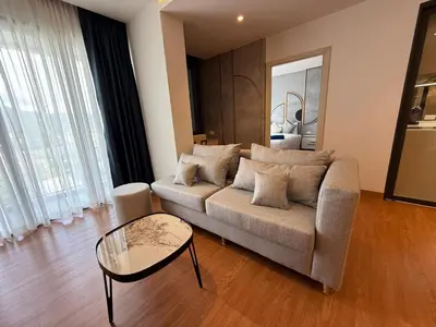 a living room with a couch and a glass table at Bellevue lagoon 2 bedrooms in Laguna Phuket