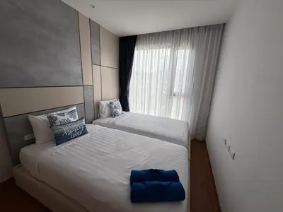 two twin beds in a room with a window at Bellevue lagoon 2 bedrooms in Laguna Phuket