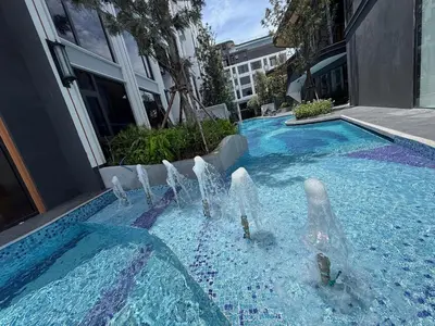 a swimming pool with a fountain in front of a building at Bellevue lagoon 2 bedrooms in Laguna Phuket