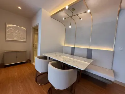 a dining room with a marble table and white chairs at Bellevue Bangtao 2 bedrooms in Laguna Phuket