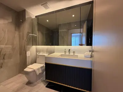 a bathroom with a sink and a toilet and a mirror at Bellevue Bangtao 2 bedrooms in Laguna Phuket