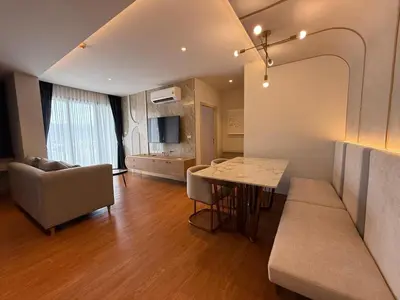 a kitchen and living room with a table and a couch at Bellevue Bangtao 2 bedrooms in Laguna Phuket