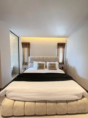 a bedroom with a large bed with a large white bedspread at Ozone vista Rawai in Ban Saiyuan (1)