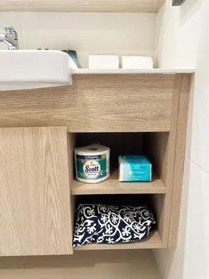 a bathroom cabinet with a sink and toiletries at Bangtao Rooftop Seaview Laguna Skypark Condominium in Bang Tao Beach