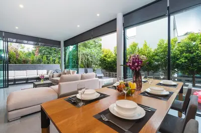 a dining room with a table and a couch at Sparrow Villa - Kamala Beach in Kamala Beach