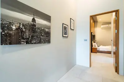 a hallway with a white wall with a picture of a city at Sparrow Villa - Kamala Beach in Kamala Beach
