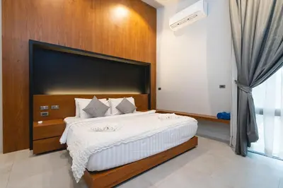 a bedroom with a large bed and a window at Sparrow Villa - Kamala Beach in Kamala Beach