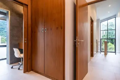 a hallway with wooden doors in a house at Sparrow Villa - Kamala Beach in Kamala Beach