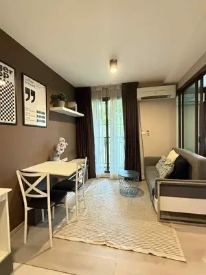 a living room with a table and a couch at Zcape garden view Phuket in Ban Rangeng