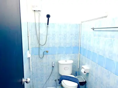 a blue tiled bathroom with a shower and a toilet at Patong Canal Villa 109 in Patong Beach