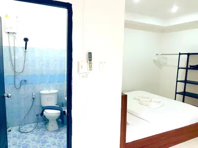 a bathroom with a toilet and a shower with a mirror at Patong Canal Villa 109 in Patong Beach