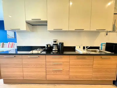 a kitchen with wooden cabinets and a sink at Veloche Peaceful Condo In Karon Beach in Karon Beach