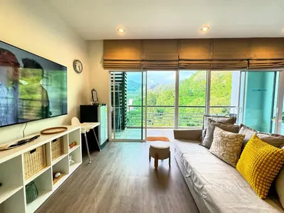 a living room with a couch and a large tv at Veloche Peaceful Condo In Karon Beach in Karon Beach