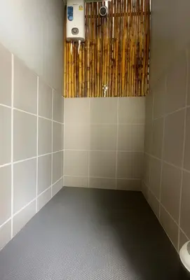 a bathroom with a toilet and a light on the wall at Beanstay hostel in Phuket Town